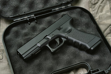 Pistol 9mm, Gun weapon series, Police handgun close-up on camouflage background.