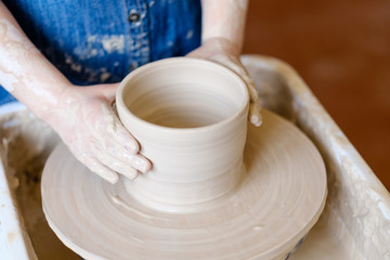 pottery handicraft skills. traditional art of creating ceramics. little crafty child potter modeling and shaping clay on turning wheel