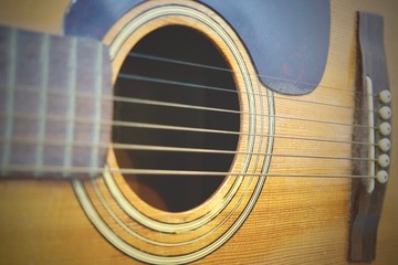 Close up of old Acoustic Guitar with very shallow depth of field, focus on strings.