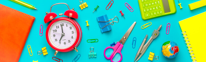 Stationary, back to school,summer time, creativity and education concept.Supplies- scissors, pencils, paper clips,note,stapler and notepad, globe on blue background,flatlay.Mock up.Top view Banner