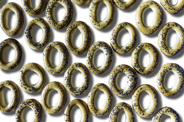 A photo of bagels with poppy seeds. Bagels arranged as a pattern. Isolated  photo on the white background for site about kitchen, food, traditions.