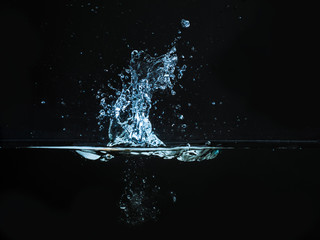 Droplet of water dropped into liquid and photographed while making splash on surface. Water splash...