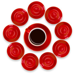 Creative layout of red coffee cups and a saucer on a white background. View from above