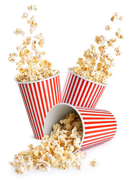 Falling popcorn in box isolated on a white background. Popcorn in striped bucket.