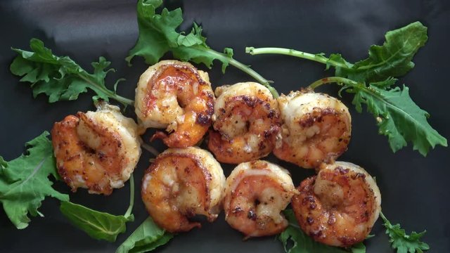 Sauteed Garlic Prawns Served on a Black Plate.