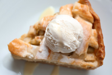 Piece of tasty apple pie with ice-cream on plate, closeup