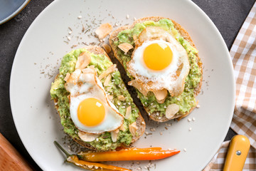 Delicious toasts with avocado and eggs on plate