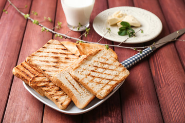 Plate with tasty toasted bread on table