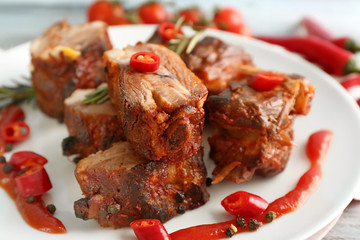 Delicious grilled ribs with sliced chili pepper on plate, closeup