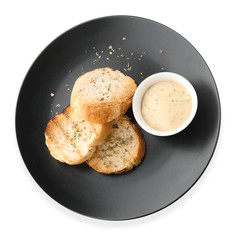 Toasted bread with herbs and sauce on plate, isolated on white