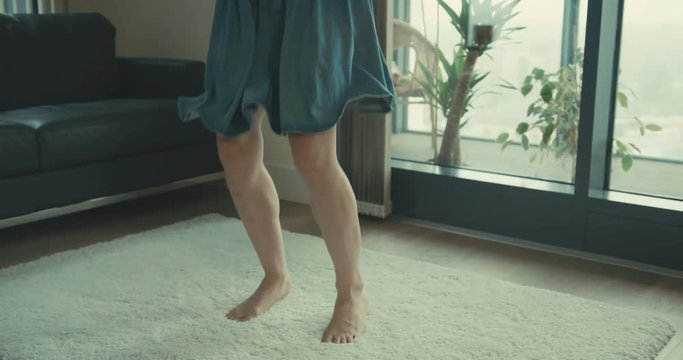 Young woman in skirt jumping around in city apartment
