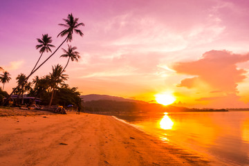 Beautiful outdoor view ocean and beach with tropical coconut palm tree at sunrise time
