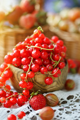 Ripe red currant on a wooden table in the garden.