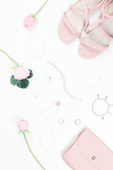 Fashion blogger workspace flat lay with sandals, jewelry, cosmetics, purse and flowers.