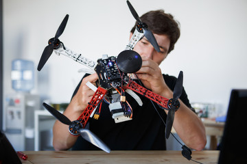 Image of engineer mending square cop sitting at table