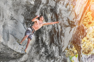 Man climbing on rock. Adrenaline, strenght, ambition