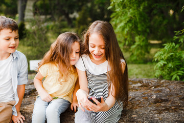 Fototapeta premium Children play smartphones during the summer holidays.