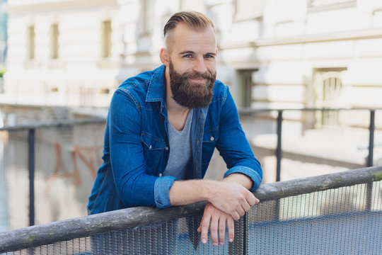 Smiling friendly man standing on a bridge