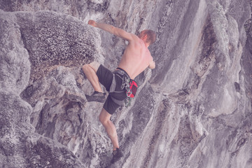 Climber climbs the cliff. Toned