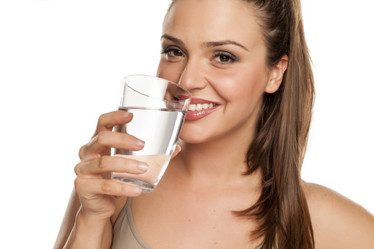 happy woman holds a glass with water on white background