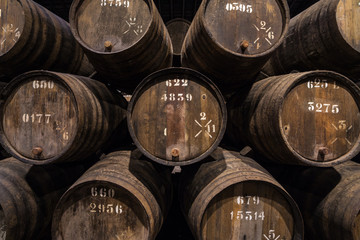 Row of wooden porto wine barrels in wine cellar Porto, Portugal.