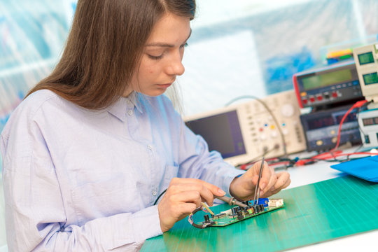 Female student in electronics class uses a Measuring device