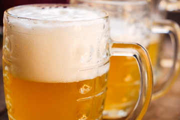 Close-up two cold beers with foam and drops.