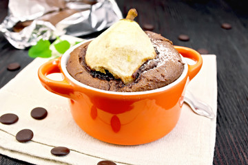 Cake chocolate with pear in red bowl on towel