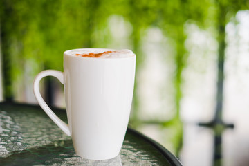 Hot chocolate in white mug on glass table for morning.