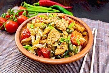 Noodles wok Thai in plate on dark board