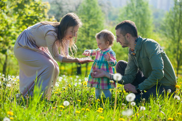 Fototapeta premium young family, mother, father, daughter, walk in the city park