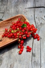 Rote Johannisbeeren in Holzschale auf rustikalem Holz  