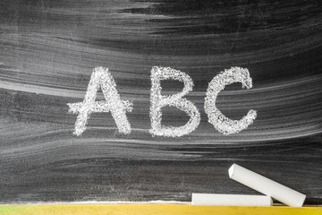 Drawn letters by chalk. Teaching abc alphabet letters for little kids on the blackboard. Education concept. 