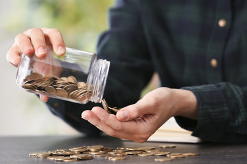 Woman holding glass jar with coins