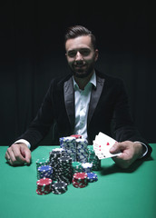 Happy poker player winning and holding a pair of aces