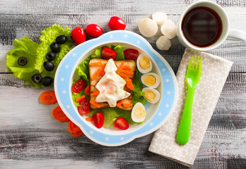 Plate with creative toast for child and cup of tea on wooden table