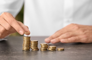 Man stacking coins on table