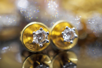 Luxury gold Jewelry diamond earrings with reflection on black background