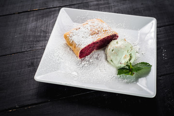 Raspberry strudel and ice cream on wooden baclground