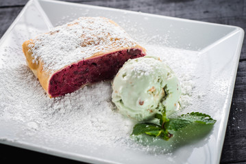 Raspberry strudel and ice cream on wooden baclground