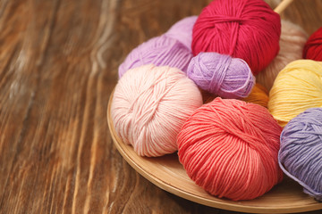 Colorful knitting yarns on wooden table