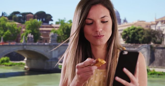 Close-up of girl taking selfie with phone while eating authentic pizza in Rome, Italy, Pretty woman taking selfie photo and eating slice of pizza outside in Rome, 4k