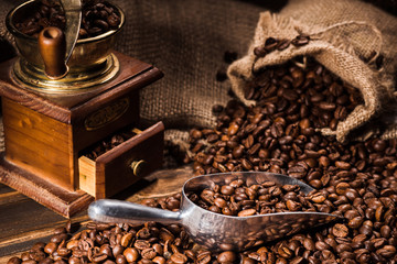 close-up shot of vintage coffee grinder with scoop and sackcloth on rustic wooden table