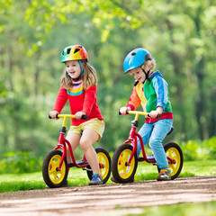 Fototapeta premium Kids ride balance bike in park