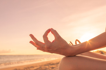 Fototapeta na wymiar Closeup of hand meditating against sunset sky. . 