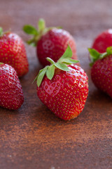 Strawberries ripe on a rustic rust background. Copy space. Healthy lifestyle concept. Vertical image
