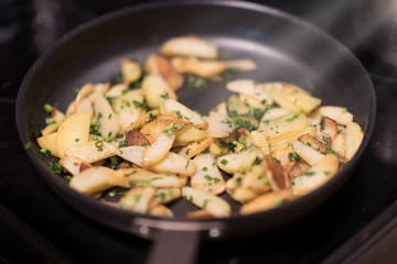 Fried potatoes with green onion on a metal pan