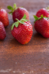 Strawberries ripe on a rustic rust background. Copy space. Healthy lifestyle concept. Vertical image