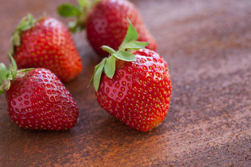 Strawberries ripe on a rustic rust background. Copy space. Healthy lifestyle concept. Vertical image