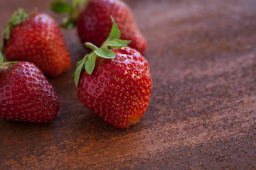 Strawberries ripe on a rustic rust background. Copy space. Healthy lifestyle concept. Vertical image